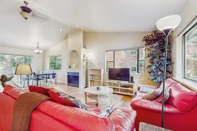 a living room with a red couch and a table at My Tahoe Sanctuary in South Lake Tahoe