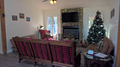 a living room with a christmas tree and a fireplace at Secluded Oasis with View, and hot tub on 50 acres in Bodfish