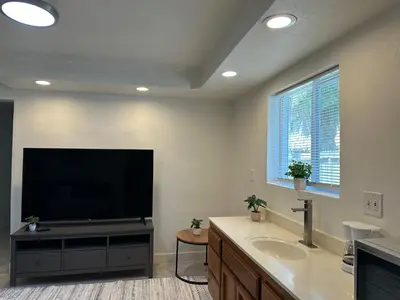 a bathroom with a flat screen tv and a sink at Suite E with 2-bedroom in Sacramento