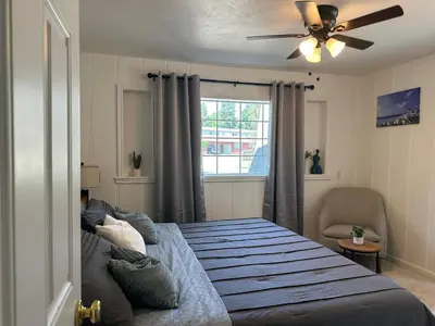 a bedroom with a bed with a ceiling fan and a window at Suite E with 2-bedroom in Sacramento
