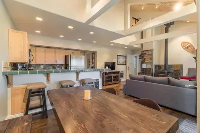 a living room with a table and a couch at Mammoth Basecamp Condo with Views near Village with AC and Fireplace in Mammoth Lakes