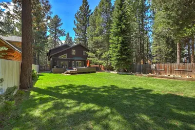 a large yard with a house in the woods at TaHaus Hot Tub Pool Table Dog Friendly in South Lake Tahoe