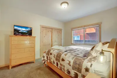 a bedroom with a bed and a dresser and a window at TaHaus Hot Tub Pool Table Dog Friendly in South Lake Tahoe