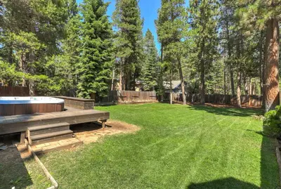 a backyard with a hot tub in the grass at TaHaus Hot Tub Pool Table Dog Friendly in South Lake Tahoe