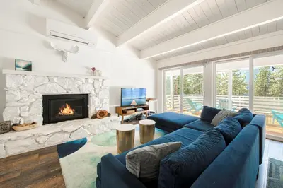 a living room with a blue couch and a fireplace at Bluejay Hideaway by Tahoe Getaways - Kings Beach 3 BR Pet Friendly w Enclosed Yard and Hot Tub in Kings Beach