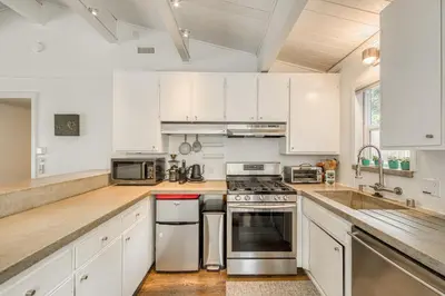 a kitchen with white cabinets and stainless steel appliances at Bluejay Hideaway by Tahoe Getaways - Kings Beach 3 BR Pet Friendly w Enclosed Yard and Hot Tub in Kings Beach