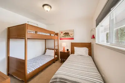 a bedroom with two bunk beds and a window at Bluejay Hideaway by Tahoe Getaways - Kings Beach 3 BR Pet Friendly w Enclosed Yard and Hot Tub in Kings Beach