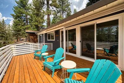 a deck with chairs and a table on a house at Bluejay Hideaway by Tahoe Getaways - Kings Beach 3 BR Pet Friendly w Enclosed Yard and Hot Tub in Kings Beach