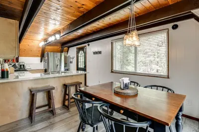 a kitchen and dining room with a wooden table and chairs at Sleek Blue Lake Springs Retreat with Deck and Yard! in Arnold