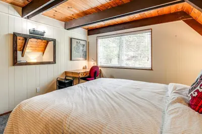 a bedroom with a bed and a desk and a window at Sleek Blue Lake Springs Retreat with Deck and Yard! in Arnold
