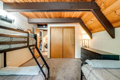 a room with two bunk beds and a wooden ceiling at Sleek Blue Lake Springs Retreat with Deck and Yard! in Arnold