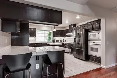 a kitchen with stainless steel appliances and black cabinets at Yosemite and Bass lake I Hot tub I Game room I Sleeps 13 in Oakhurst