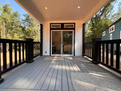 a large wooden deck with a glass door at Tiny Blanca at Yosemite Gateway in Groveland