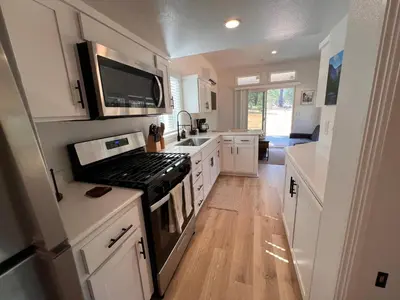 a kitchen with white cabinets and a stove top oven at Tiny Blanca at Yosemite Gateway in Groveland