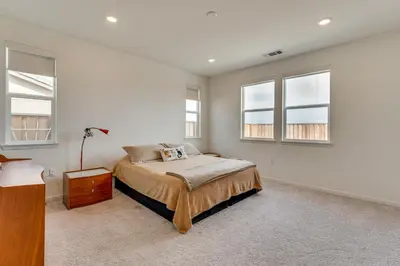 a bedroom with a bed and two windows at Newly Built Home with Patio 4 Mi to Dtwn Hollister in Hollister