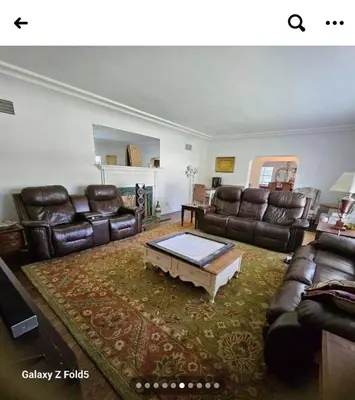 a living room with leather couches and a coffee table at Peaceful family home in Fresno