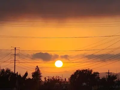 a sunset with power lines and the sun at Peaceful family home in Fresno