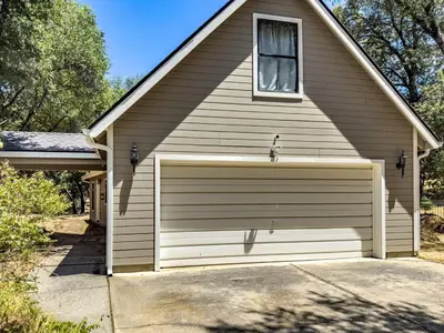 a brown house with a garage at Studio Loft Near Yosemite with Kitchenette in Oakhurst