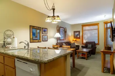 a kitchen with a sink and a living room at Ski in/Out 1B/1BA w/ View - Pool, Jacuzzi, Parking in Mammoth Lakes