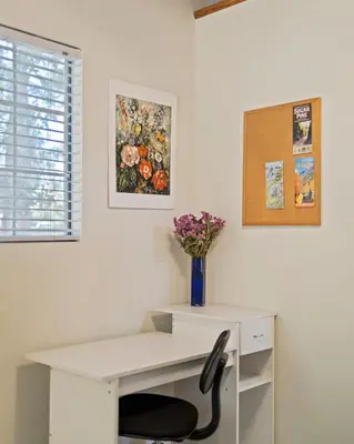 a white desk with a vase of flowers on it at Red Cabin in Twain Harte - King bed in Twain Harte