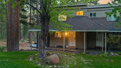 a house with a tree in front of it at Cozy Forest Hideaway in Incline Village Private Balcony Sierra Solace by AvantStay in Incline Village