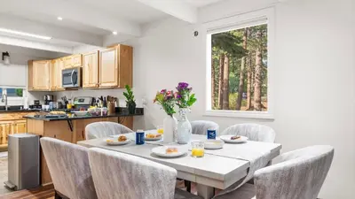 a dining room with a table and chairs and a kitchen at Cozy Forest Hideaway in Incline Village Private Balcony Sierra Solace by AvantStay in Incline Village