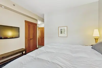 a bedroom with a white bed and a flat screen tv at Ski-InandSki-Out Condo with Views in Olympic Valley in Olympic Valley