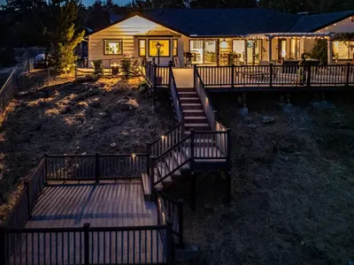 a house with stairs leading to a porch with lights at Yosemite Luxe Family Lodge - Spa, Theater, Sauna, EV, Game Room, Poker Table in Mariposa