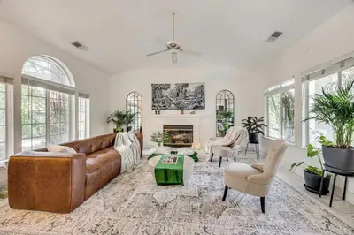 a living room with a brown leather couch and a fireplace at Rudraksha-5BR Luxury,3Bath, NE Fresno, Shopping, Dining, Medical, Tourist Attractions in Fresno