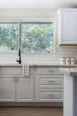 a kitchen with white cabinets and a window at 7BR 3Bath in Yosemite & Bass Lake with BBQ & Hot Tub in Oakhurst
