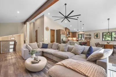 a living room with a large couch and a kitchen at Song of the Sierras - 4 Bed, 4 Bath Luxury Tahoe Home in South Lake Tahoe