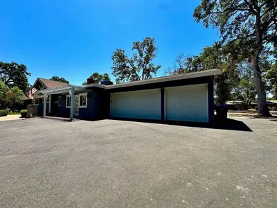 a house with two garage doors in a driveway at Peaceful Country Getaway Near Casino Shopping in Placerville
