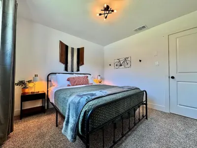 a bedroom with a bed with a blue blanket on it at Pool Remodeled 4 Bedroom Carmichael Home in Carmichael