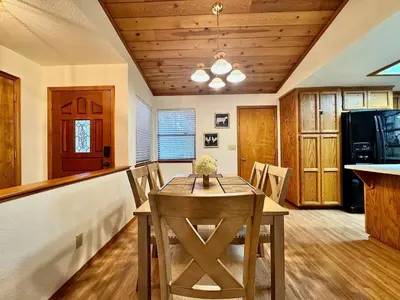 a dining room with a table and a kitchen at Forest View Family Home in Pollock Pines