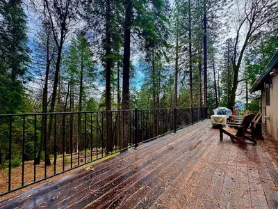 a wooden deck with benches and a fence at Forest View Family Home in Pollock Pines