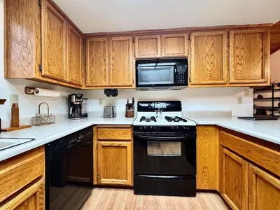 a kitchen with wooden cabinets and a black stove top oven at Forest View Family Home in Pollock Pines