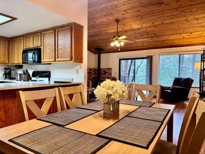 a kitchen and dining room with a table with flowers on it at Forest View Family Home in Pollock Pines