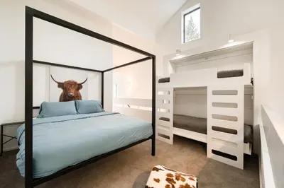 a bedroom with a bed with a cow head on the wall at River Run # 15 by Tahoe Getaways - 2 BR w Private Balcony, River Views & Shuttle in Alpine Meadows
