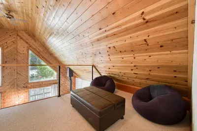 a room with a wooden wall with two chairs and a couch at Hearthlight Cabin at Tahoe Donner by Tahoe Getaways - Pet-Friendly 3BR w Guest Suite in Truckee
