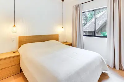 a bedroom with a white bed and a window at 4 Mi to Soda Springs Resort Hot Tub Hideaway! in Soda Springs