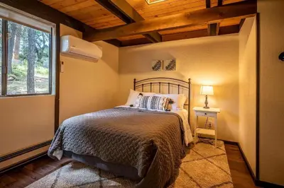 a bedroom with a bed and a window at Woodland Chalet Retreat with Hot Tub in Arnold