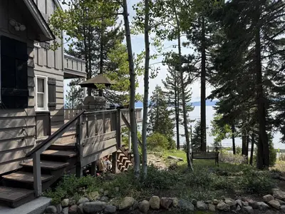 a house with a wooden staircase next to a house with a bench at Lake Tahoe Cabin I Hammocks, Paddle Boards and Bikes in Homewood