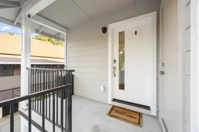 a front porch with a white door and a welcome mat at Cozy Nest Across the street from UC Davis Sacramento in Sacramento