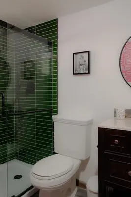 a bathroom with a toilet and a shower with green tiles at A-Frame Cabin - Sauna, Hot Tub, Fire Pit, Projector in Arnold