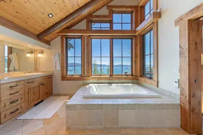a large bathroom with a large tub and windows at Beyond the Blue Lakefront Escape by Tahoe Getaways - Pet-Friendly 6BR with Pier, Buoy & Hot Tub in Carnelian Bay