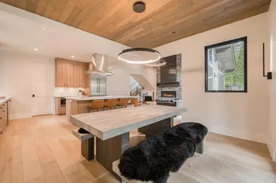a kitchen with a large wooden table and a dining room at Shining Creek at Alpine Meadows by Tahoe Getaways - 4 BR w Creek Views, Hot Tub & Ski Shuttle! in Alpine Meadows