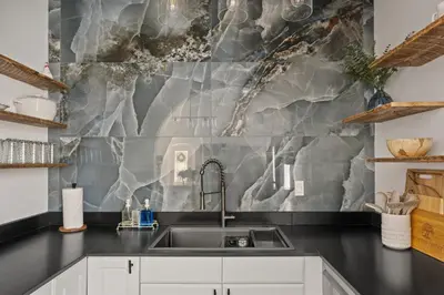 a kitchen with a sink and a marble wall at Historic 1914 Cottage, Near Downtown, UNR & Hospitals, Early Check In in Reno