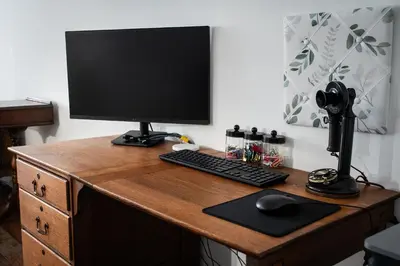 a desk with a computer monitor and a keyboard and mouse at Historic 1914 Cottage, Near Downtown, UNR & Hospitals, Early Check In in Reno