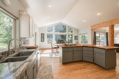 a kitchen with gray cabinets and a large window at Emerald Lodge at Tahoe Park by Tahoe Getaways - 4BR w HOA Beach & Air Conditioning in Tahoe City