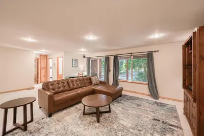 a living room with a brown leather couch and tables at Emerald Lodge at Tahoe Park by Tahoe Getaways - 4BR w HOA Beach & Air Conditioning in Tahoe City